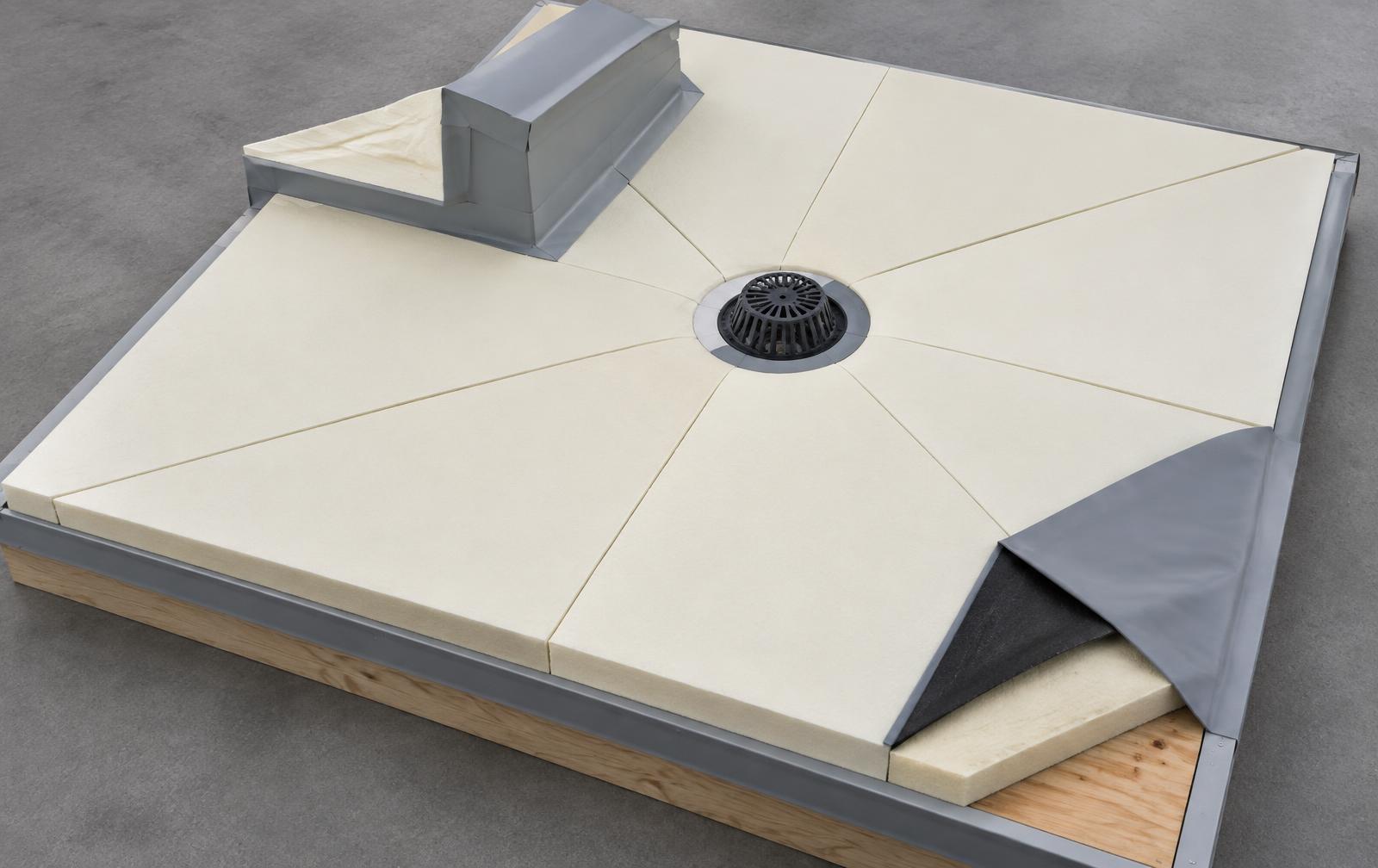 Training mock-up showing tapered roof boards guiding a slope toward a drain.